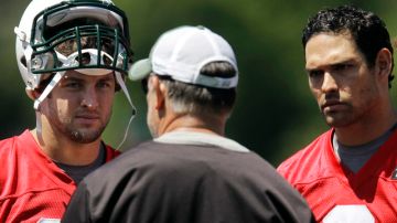 Los quarterbacks Mark Sánchez (der.) y Tim Tebow (izq.) escuchan las indicaciones de uno de los coaches de los Jets, Matt Cavanaugh.