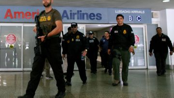 Agentes federales escoltan a uno de los detenidos en el aeropuerto de San Juan.