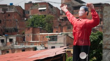 Fotografía en la que se observa un muñeco hinchable del presidente venezolano Hugo Chávez, de cinco metros, con el puño en alto, camisa roja y sonriente.