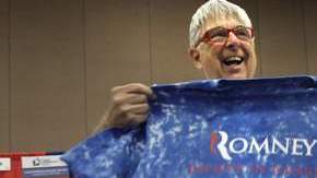 Favorecedores de Mitt Romney muestran unas camisetas con los colores patrios y el nombre de su candidato.