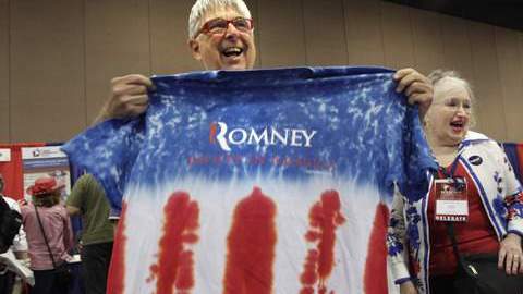 Favorecedores de Mitt Romney muestran unas camisetas con los colores patrios y el nombre de su candidato.