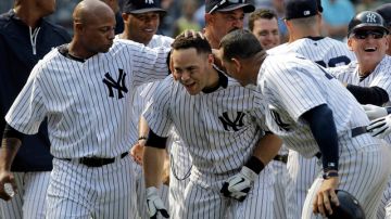 Dewayne Wise (izq.) y  Alex Rodríguez (der.) felicitan a Russell Martin (centro) luego que éste conectara el jonrón que le dio la victoria a los Yankees  sobre  Mets.