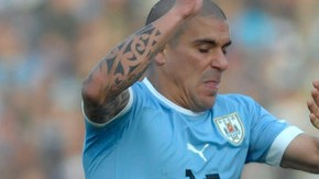 Maximiliano Pereira, de Uruguay, intenta despojar del balón al peruano Paolo Guerrero (9) en el juego celebrado en el Estadio Centenario.