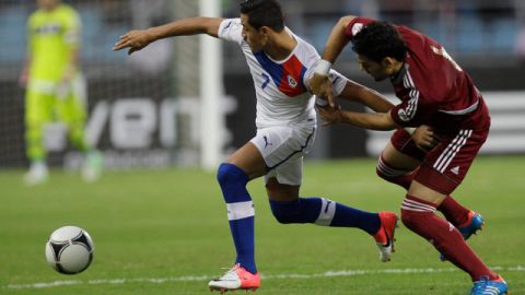 Gabriel Cichero jala del brazo a Alexis Sánchez en el partido del sábado por la eliminatoria sudamericana.