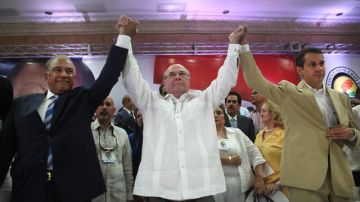 El expresidente Hipólito Mejía (c) levanta los brazos con el presidente del Partido Revolucionario Dominicano (PRD), Andrés Bautista (i), y el secretario general, Orlando Jorge Mera (d), durante la reunión del Comité Ejecutivo Nacional.