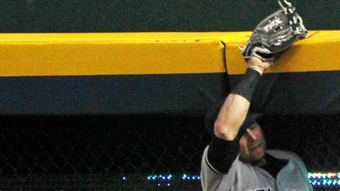 El jardinero derecho de los Yankees, Nick Swisher, realiza una espectacular atrapada evitando un jonrón de Brian McCann de los Bravos.