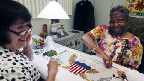 Nereida Rivera (i) y Christine Upchurch, ambas de Filadelfia, bordan a mano una bandera de la Vicepresidencia en la Agencia Logística de Defensa, en Filadelfia.