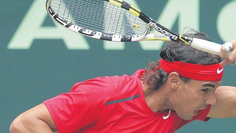 Rafael Nadal devuelve un tiro de Philipp Kohlschreiber, quien ayer le eliminó sobre la grama del torneo de Halle, Alemania.