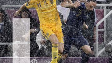 Bajo un torrencial aguacero, Frank Ribery (der.) lucha por el balón con el ucraniano Andriy Yarmolenko.