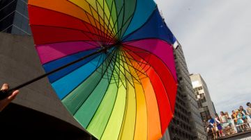 Participantes en el Desfile Gay en Brasil despliegan una sombrilla con los colores del arcoíris.