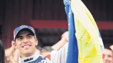El corredor de autos Pastor Maldonado alza la bandera de Venezuela tras su victoria en el Gran Premio de Cataluña, en Barcelona, España.