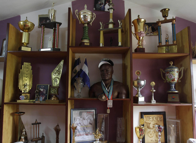 Una escultura de madera del ex campeón mundial amateur de boxeo Félix Savón, que le dio un aficionado, junto a medallas y trofeos, en su casa en La Habana.
