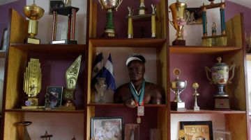 Una escultura de madera del ex campeón mundial amateur de boxeo Félix Savón, que le dio un aficionado, junto a medallas y trofeos, en su casa en La Habana.