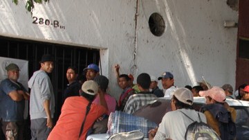 Un grupo de inmigrantes espera el paso del tren de carga en  Guadalajara, Jalisco, vía más larga pero más segura.