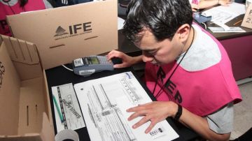 Un trabajador de casilla del IFE revisa una boleta ayer durante la realización del tercer simulacro  nacional.