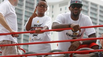 El estelar LeBron James (der.) disfruta de la parada junto a su hijo LeBron Jr.