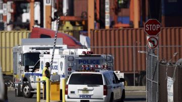 Policías rodearon esta mañana el barco de carga a su llegada al puerto de Newark.