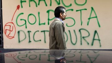 Un hombre pasa frente a un grafitis pintado en una calles de Asunción