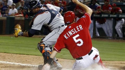 El catcher de los Tigres Gerald Laird (9) intenta atrapar demasiado tarde a Ian Kinsler de los Rangers (5) que se desliza y marca en el octavo inning.