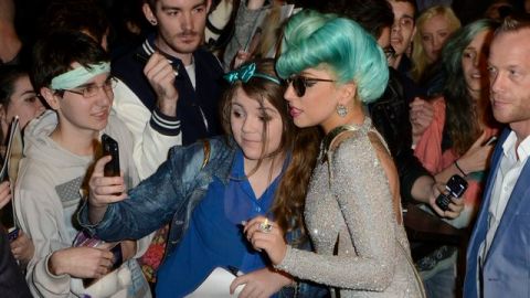 Lady Gaga  posa junto a una admiradora a las puertas de su hotel en Sídney, Australia, donde se encuentra de gira.