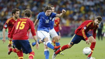 El italiano Riccardo Montolivo (c) lucha por el balón con Gerard Pique (d) y Jordi Alba (i) de España.