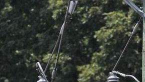 Empleados del servicio eléctrico trabajaban hoy para desenmarañar cables eléctricos y retirar ramas caídas para devolver el flujo eléctrico.