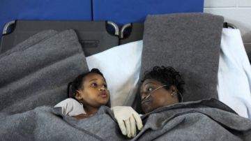 Marcia McCloud descansa junto a su nieta Makayla Milton en un refugio provisto por la Cruz Roja en Lynchburg, Virginia.