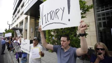 John Boyle, de Seattle, sostiene un cartel durante una manifestación el para celebrar la reforma de salud.