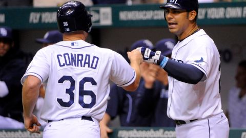 El primera base dominicano Carlos Peña (der.) felicita a Brooks Conrad luego que éste anotara la carrera del triunfo de los Rays 4-3 sobre los Yankees.
