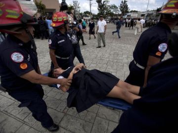 Una estudiante es transportada por rescatistas  después de disturbios en Ciudad de Guatemala que dejaron más de 50 personas lesionadas, algunas de gravedad.