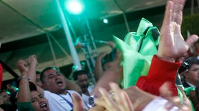 Peña Nieto saluda a sus correligionarios en la madrugada del lunes tras anunciarse su  ventaja en los resultados rápidos del IFE.