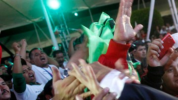 Peña Nieto saluda a sus correligionarios en la madrugada del lunes tras anunciarse su  ventaja en los resultados rápidos del IFE.