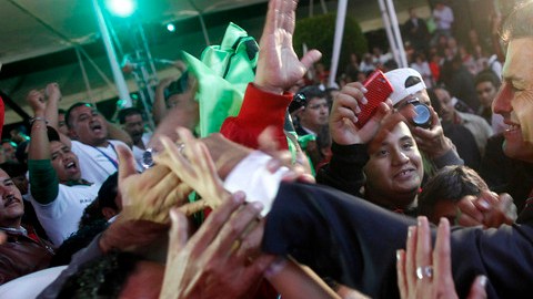 Peña Nieto saluda a sus correligionarios en la madrugada del lunes tras anunciarse su  ventaja en los resultados rápidos del IFE.