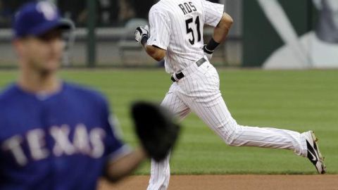 El boricua Alex Ríos, de los Medias Blancas, recorre las bases luego de haber  descargado jonrón a Roy Oswalt (izq.) en el primer inning.