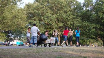 Un vendedor ambulante ofrece 'chinanpines' a un grupo de niños y adolescentes en un parque de El Bronx, quienes luego se los lanzan unos a otros.