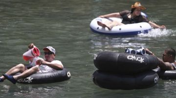 Beber cerveza mientras los bañistas flotan plácidamente por el río en New Braunfels es una tradición para cientos de miles de turistas que visitan el lugar cada verano.