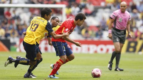 Miguel Sabah (der.) delantero del Morelia escapa a la marca de dos jugadores  del América duante la fecha doce del torneo mexicano.