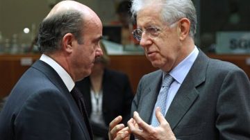Monti (derecha) habla con el Ministro de Finanzas español, Luis de Guindos hoy en Bruselas.