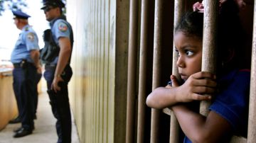 En la foto de archivo, una alumna  espera para ser recogida después de  clases mientras policías vigilan las calles,  en  San Juan, Puerto Rico.