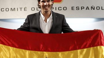 El tenista español Rafael Nadal muestra la bandera de España que portará en la ceremonia de inauguración de los Juegos Olímpicos de Londres 2012.