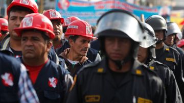 Escoltados por agentes de la policía,   trabajadores de la construcción marchan durante una protesta contra el proyecto minero de oro y plata Conga en Lima.