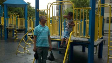 José Rodríguez, de 64 años, junto a su nieto Jael, de cinco años, quien se queja de la falta de agua en el parque Raoul Wallenberg Playground de su vecindario.