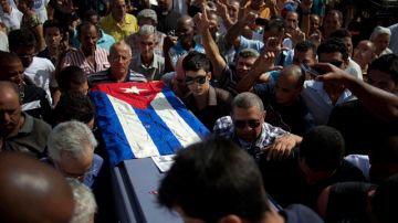 Parientes y amigos del opositor cubano Oswaldo Payá transportan su féretro cubierto con la bandera de su país en el cementerio donde se realizó ayer el funeral en La Habana, Cuba. Payá falleció el domingo en un accidente de tráfico.
