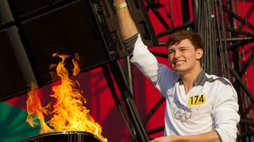 Tyler Rix, de Londres, el último portador de la antorcha olímpica, enciende la flama en el escenario del  Relay Concert en Hyde Park.