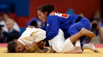 Sara Menezes de Brasil somete en el dojo a Laetitia Payet de Francia, durante los Juegos Olímpicos de Londres.