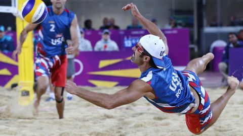 El estadounidense Phil Dalhausser, izq, observa a su compañero Todd Rogers, lanzarse por el balón en su partido contra Japón en los juegos olímpicos de Londres 2012.