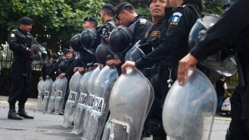 Agentes de la Policía Nacional Civil (PNC) resguardan las instalaciones del Instituto Normal para Varones  luego de enfrentarse con estudiantes quienes quieran ocupar el instituto, en el sur de Ciudad de Guatemala.