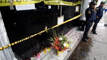 Policías en guardia junto a un altar en el club News Divine, donde 12 personas murieron en una estampida, el, 24 de junio de 2008.