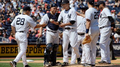 El piloto Joe Girardi (izq.) saca al abridor Hiroki Kuroda (bola en mano) tras éste último golpear con un lanzamiento a Brendan Ryan, de los Marineros de Seattle, en la entrada siete del partido de ayer.