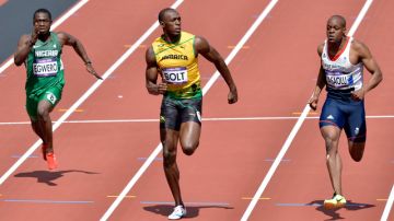 Usain Bolt (al centro), de Jamaica, domina sin problemas su eliminatoria de ayer de los 100 metros lisos.